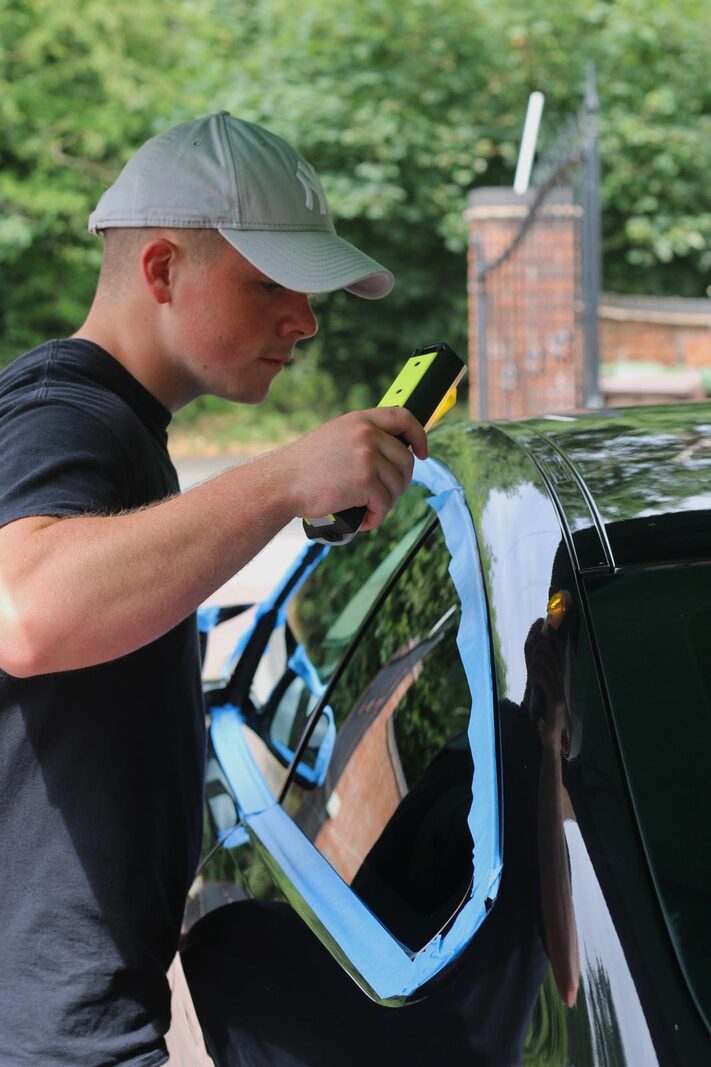 Inspecting masked paintwork with a detailing light before machine polishing, Solihull